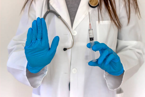 istock Syringe in doctor hand and sign STOP. 1293597198
