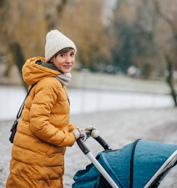 Winter walk Mother walking with a stroller through the winter park baby stroller winter stock pictures, royalty-free photos & images