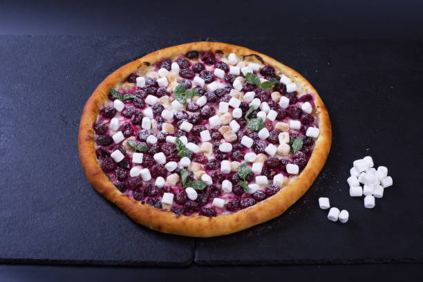 istock A beautiful pizza with tomatoes, meat and cheese lies on a dark stone table 1293598174