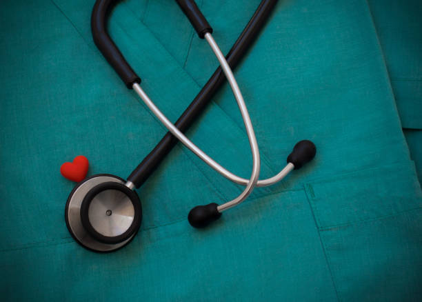 Stethoscope and red heart on green scrubs background Stethoscope and red heart on green scrubs background, top view. Medical objects. Cardiology concept. World health day and healthcare concept. Black stethoscope for doctor diagnostic coronavirus disease red medical scrubs stock pictures, royalty-free photos & images