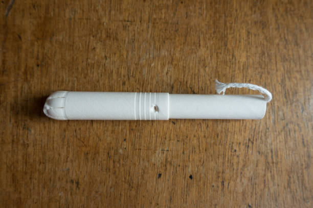 tampón único con aplicador de cartón sobre mesa de madera desde arriba - tampon menstruation applicator hygiene fotografías e imágenes de stock