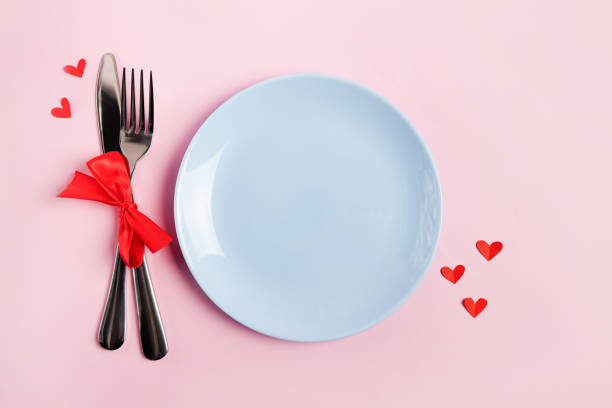 istock Festive table setting for Valentines Day with blue empty plate on pink table with red hearts 1293602732