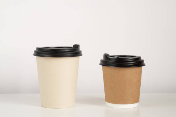 istock Two coffee cup mockup on the white background. Empty cups for americano and cappuccino on the table 1293603135