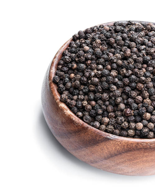 istock Black pepper corn in wooden bowl isolated on white 1293603267