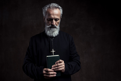 Priest holding Holy Bible