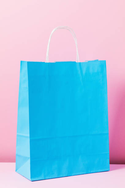 istock Blue paper bag on pink background, close-up 1293604658