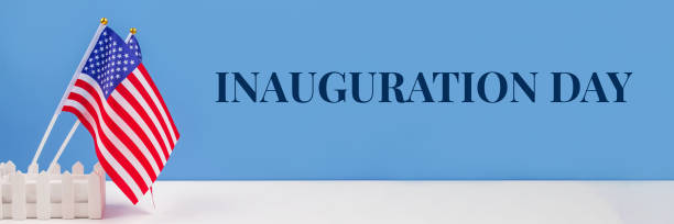 istock Banner with USA flags on white table against blue wall background, copy space for your text. Inauguration Day 2021 concept 1293606572
