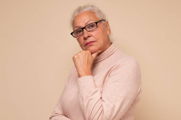 istock old woman with glasses looking confident at camera. 1293607166