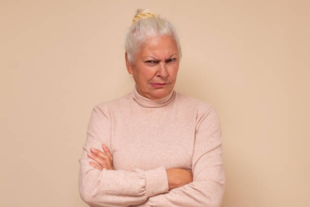 istock Suspicious elderly woman showing distrustful look at camera 1293607866