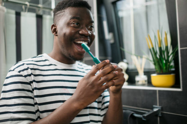 istock Young African American man brushing his teeth at home 1293607904