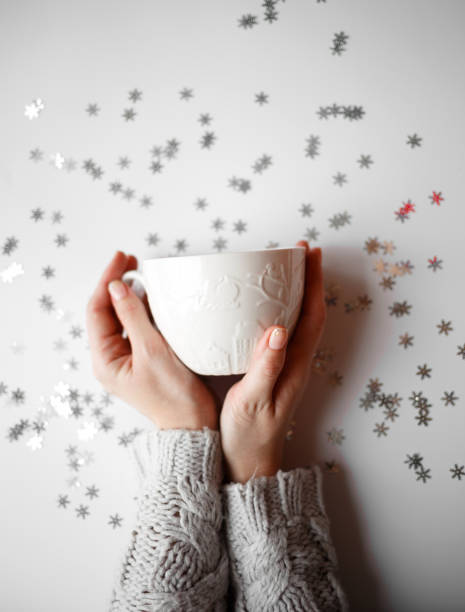 cup with marshmallows on a white background with silver snowflakes