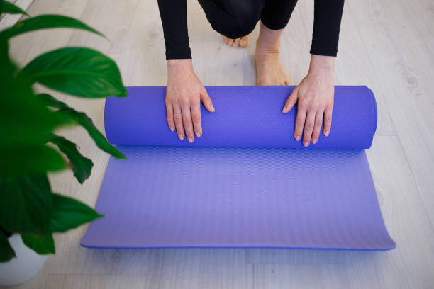 istock young woman unfolds yoga mat before practice 1293610008