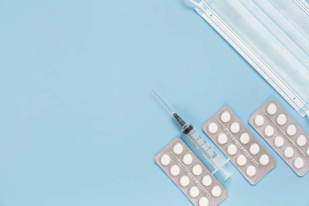 istock Protective face mask, packaging with pills and expendable syringe. Coronavirus vaccination concept and other infection diseases. 1293611293
