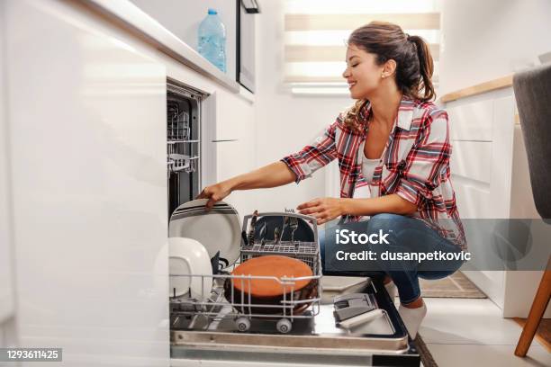 Diligent Housewife Putting Dishes Into Dishwasher Stock Photo - Download Image Now - Dishwasher, Loading, Unloading