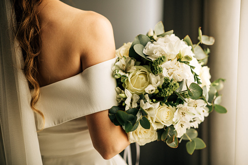 Young female bride holding her flower bouquet