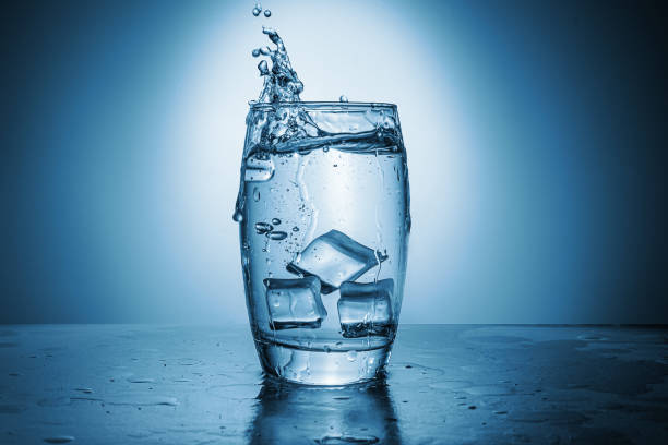 een glas water, citroen en ijs - glas water stockfoto's en -beelden