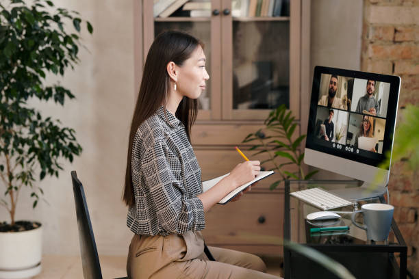 istock Side view of young office manager making notes in front of computer monitor 1293621261
