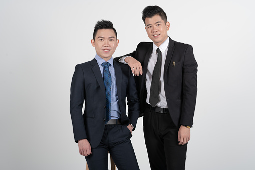 2 Asian Chinese young businessmans with coat in white background studio