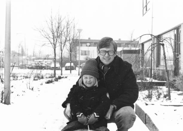 Vintage father and daughter winter portrait 1978 vintage, seventies, retro monochrome portrait of father and daughter in winter snow setting in a suburban area. ice skating photos stock pictures, royalty-free photos & images
