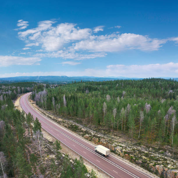 Delivery truck on a highway through a forest