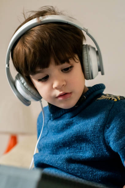istock A young boy playing piano with headphones 1293627673