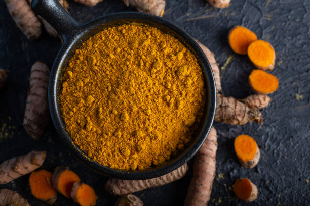 istock Turmeric powder in bowl on black background. 1293629067