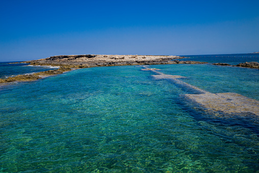 Sea water swimming pool with extraordinary clean and transparent water at the aerial training aid for WWII in Qawra Point Beach, Saint Paul,s Bay,  Malta