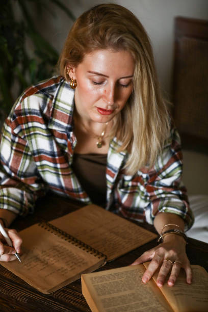 istock Blonde-Haired Woman Reading And Using A Candlelight Book, inspiration And Writing 1293630121
