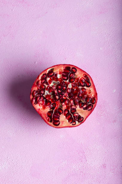 Pomegranates cut open with pomegrante seeds. Fruit minimalism creative concept.