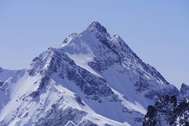 istock Beautiful snow-capped mountain peak under the sunny sky 1293634581