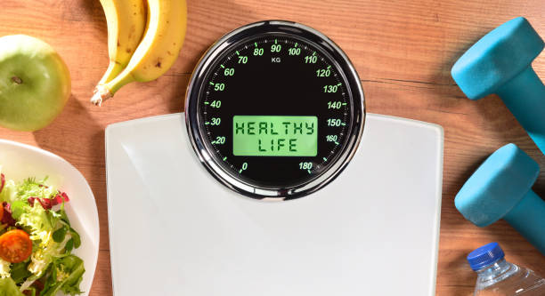 istock Healthy life background with weighing scale with message and objects 1293637730