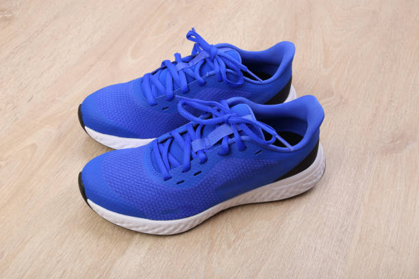 istock Blue running shoes on wooden background 1293638114
