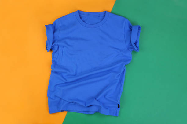 istock Wrinkled blue tshirt on green and orange background 1293638177