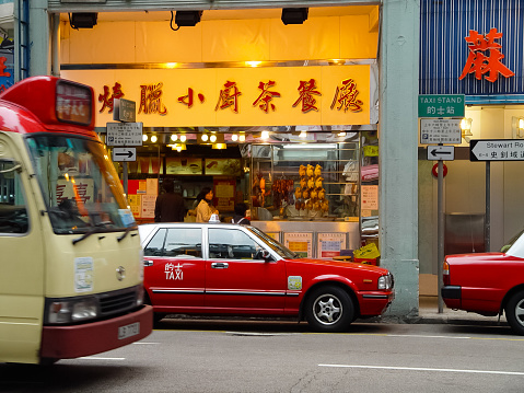 Hong Kong, China - June 14, 2019: Cars and buses drive down the street at night in the throat. Streets of Hong Kong night. Night lights of the city of Hong Kong.