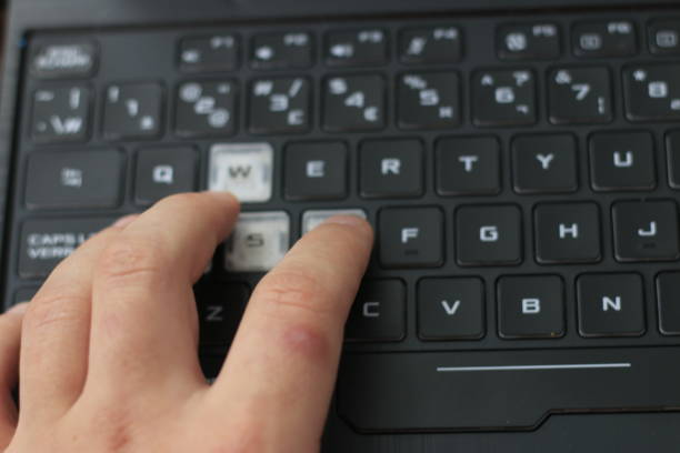 istock male hand next to a gaming laptop. Technology in use 1293640172