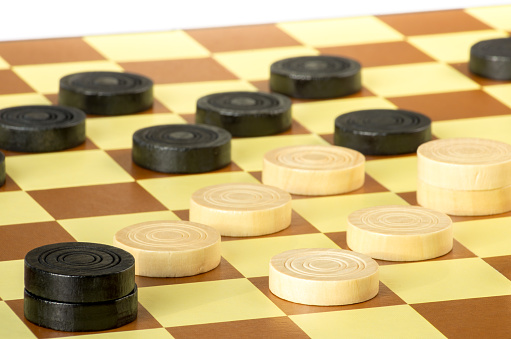 checkers or draughts is a board game. Close Up of wooden round checkers. white background.