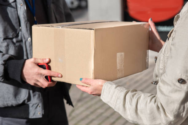 istock Delivery courier delivers package to woman, up close 1293645207
