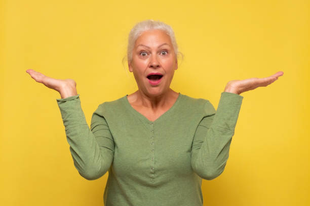 istock Smile senior woman holding something on open palms. 1293648158