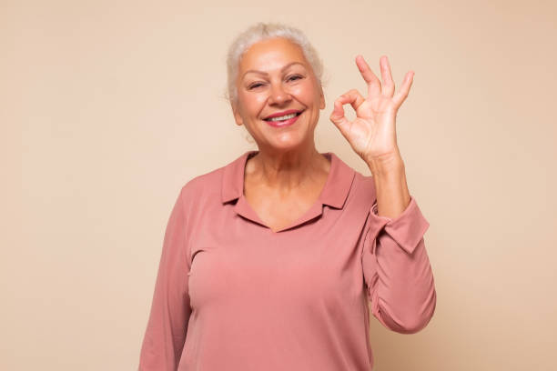 istock Senior woman doing ok gesture with hand smiling approving your choice. 1293648451
