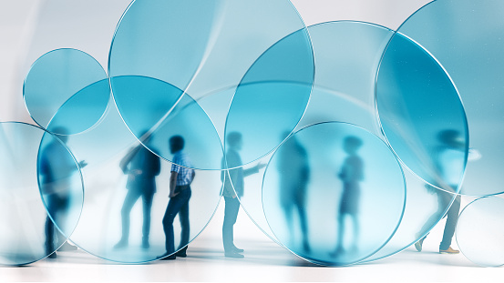 A group of business people standing behind blue glass circles. All elements in the scene are 3D