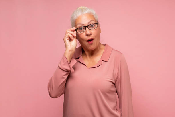 istock Surprised senior woman looking through glasses notices something unexpected 1293649664