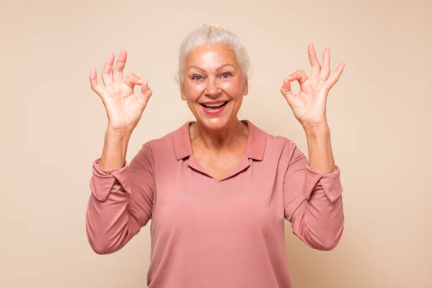 istock Senior woman doing ok gesture with hand smiling approving your choice. 1293650618