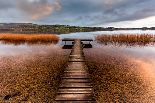 An old wooden pier on a calm lake in the heart of Ireland