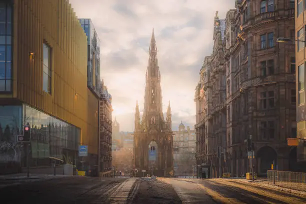 A view of the Sir Walter Scott Monument on Princes Street in Edinburgh on a winter's morning as golden light breaks through.