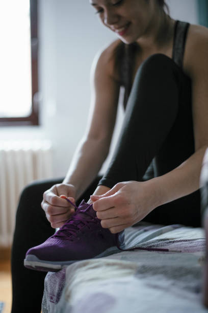 istock Young woman tying her shoelaces before a workout 1293660469