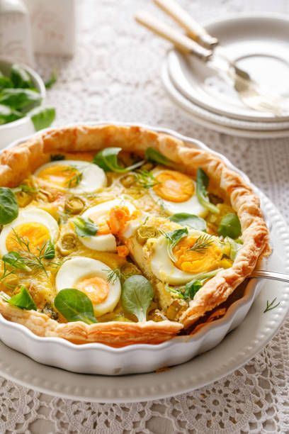 istock Quiche with with boiled eggs and leeks sprinkled with fresh dill and lambs lettuce served in casserole dish 1293661412
