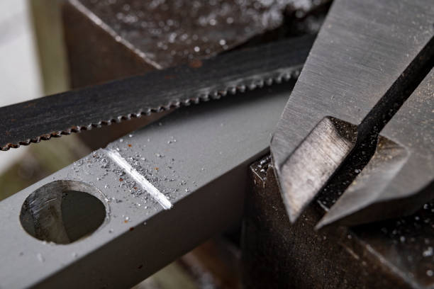 istock Cutting aluminum with a handsaw. Locksmith works performed as an amateur. Workplace home workshop. 1293661767