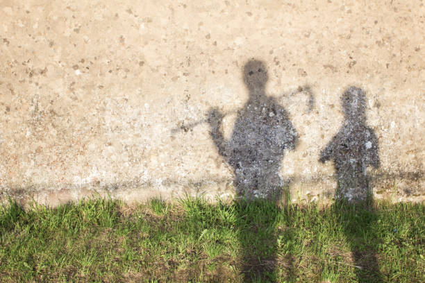 istock shadow of two farmers projected on a cement wall and a grass path. space for text 1293665553