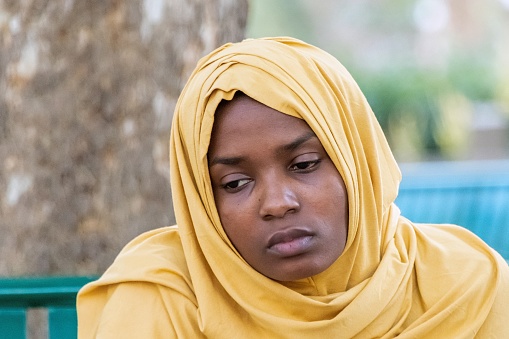Pensive serious young black muslim woman wearing a hijab looking at camera
