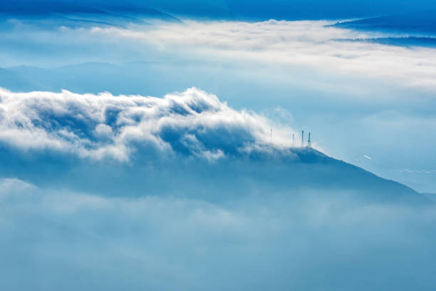 Landscape shot of mountains and dramatic clouds mixed with fog in winter